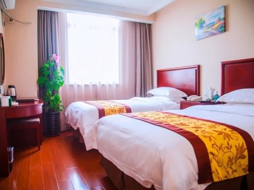 上海格林豪泰上海闵行区浦江镇江月路地铁站商务酒店的酒店客房设有两张床和窗户。