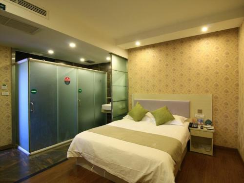 温州格林豪泰温州鹿城区小南门快捷酒店的一间卧室设有一张大床和玻璃淋浴间