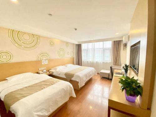 天津格林豪泰天津西青秀川路阳光100的酒店客房设有两张床和电视。
