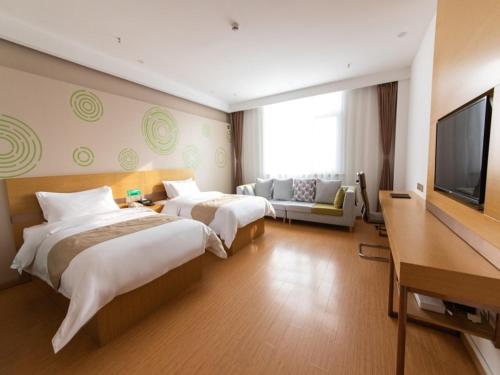 涿州格林豪泰保定市涿州市火车站商务酒店的酒店客房设有两张床和一台平面电视。