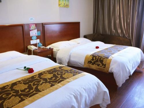 涡阳格林豪泰涡阳胜利路阜阳商厦快捷酒店的酒店客房,配有两张带白色床单的床