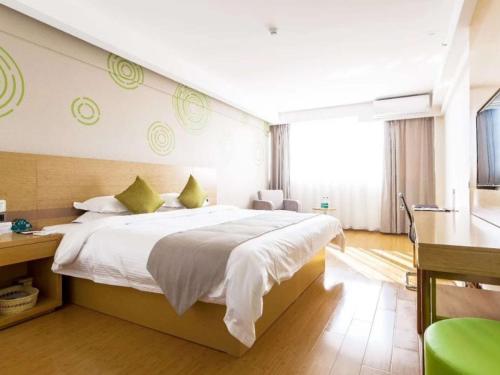泗州格林豪泰宿州泗县汴河大道商务酒店的一间卧室配有一张大床和一张书桌