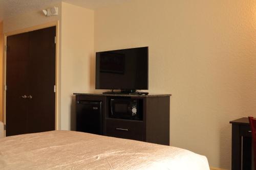 西棕榈滩Pioneer Inn的卧室配有梳妆台上的平面电视