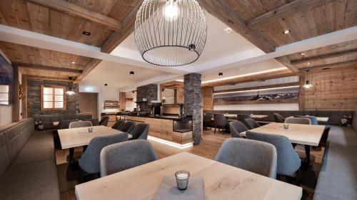 伊施格尔Hotel Tanzer的餐厅拥有木墙和桌椅