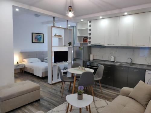 都拉斯E&A Apartments Guesthouse的厨房以及带床和桌子的客厅。