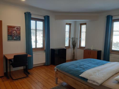 克拉尼Triglav Apartment House的卧室配有一张床、一张书桌和窗户。