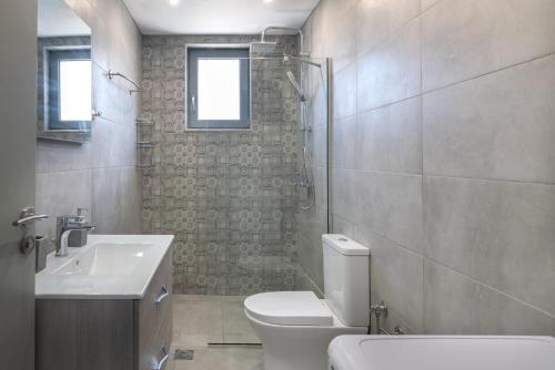 Áyios KonstandínosVilla Sofia的浴室配有卫生间、盥洗盆和淋浴。