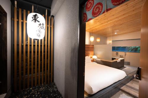 礁溪东旅汤宿温泉饭店-风华漾馆的一间设有白色床的卧室和一张书桌