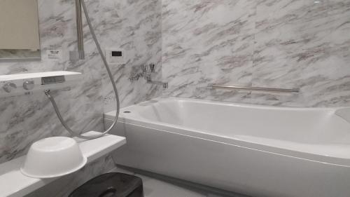 金泽Mon Petit Chat的浴室配有白色浴缸和白色卫生间。
