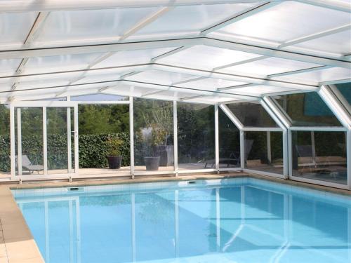 福卡尔基耶Chambre D'hôte La Beaudine的铝制泳池房屋,带遮阳篷和游泳池