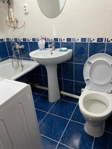 卡拉甘达Домашний уют的蓝色瓷砖浴室设有卫生间和水槽