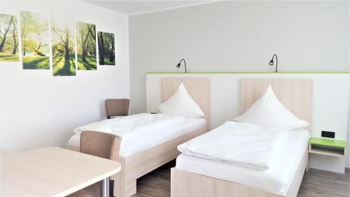 拉德贝尔根埃斯彭霍夫汽车旅馆的一间设有两张床和一张桌子的房间