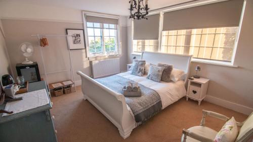 拉伊Red Cottage B&B的卧室设有一张白色大床和两个窗户。