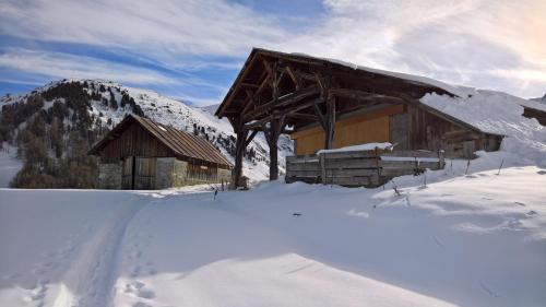 LongefoyHôtel et Appart'Hôtel Restaurant L'Adray的雪中的一个小木屋,有山