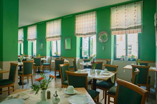 莱比锡亚达吉奥酒店的餐厅拥有绿色的墙壁和桌椅