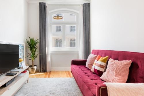 里斯本奥古斯塔街213号公寓 - 您在里斯本的家的客厅设有红色的沙发和窗户。
