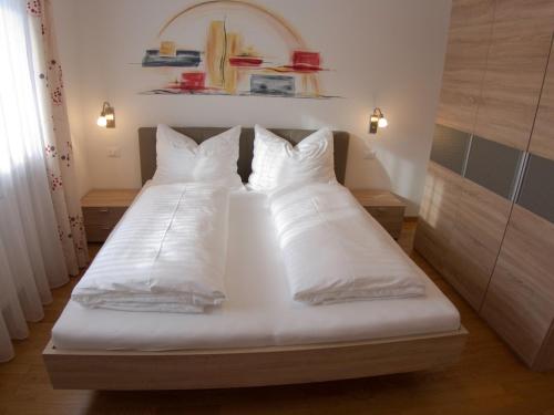 瓦尔道拉Appartement Gandler的一间卧室配有两张带白色床单和枕头的床。