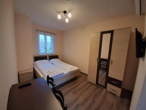 SzécsényBársony Vendéglő és Panzió的一间卧室配有一张床、一张桌子和一面镜子