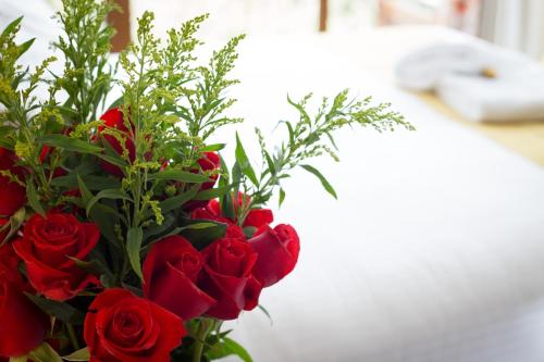 基多Ilalo Garden Hotel & Restaurant的花瓶里一束红玫瑰