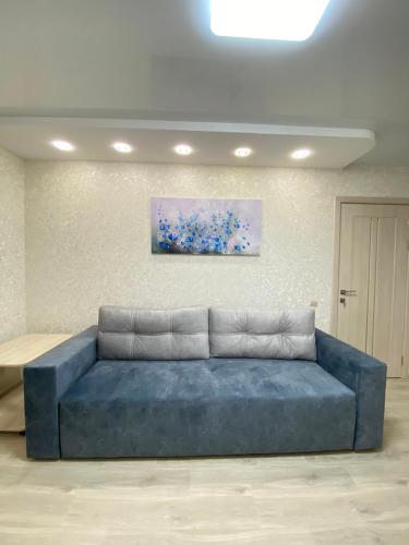 切尔尼戈夫Suite Mira Avenue Center Двухкомнатная Квартира в центре возле ТЦ ЦУМ的墙上画画的蓝色沙发