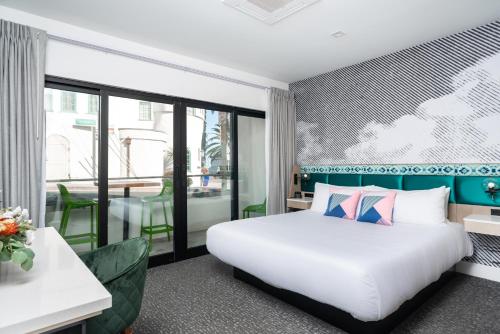 阿瓦隆Bellanca Hotel的酒店客房设有一张床和一个阳台。