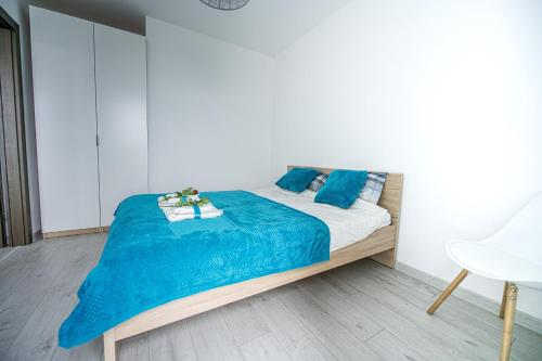 罗兹Apartments Drewnowska 43的一间卧室配有一张带蓝色毯子的床