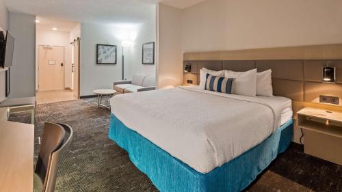 奥加拉拉奥加拉拉康福特茵酒店的酒店客房带一张大床和一把椅子