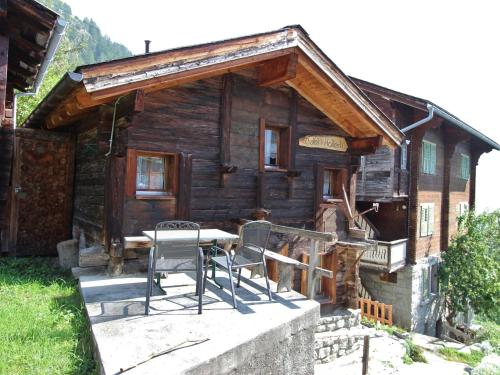 Bettenwooden chalet in Betten near the Aletsch Arena的小屋前方设有桌椅