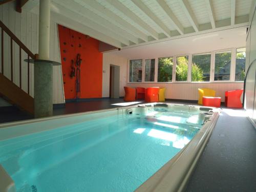 韦姆埃库里迪拉克度假屋的一个带橙色椅子的房间的大型游泳池