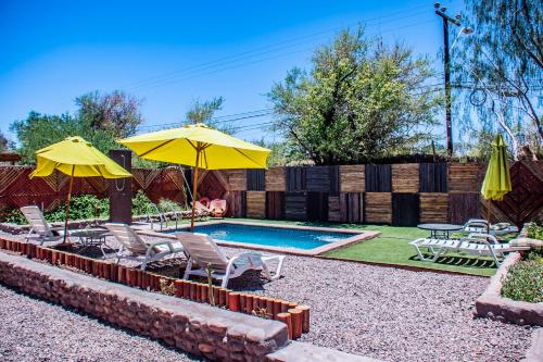 圣佩德罗·德·阿塔卡马San Pedro Domos的后院设有带椅子和遮阳伞的游泳池