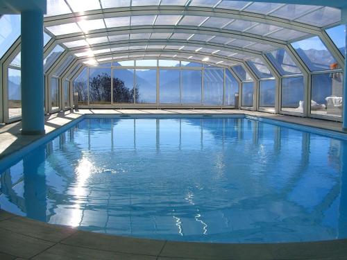 斯泰尼科Belvilla by OYO Villa Stenico的一个带玻璃天花板的大型游泳池