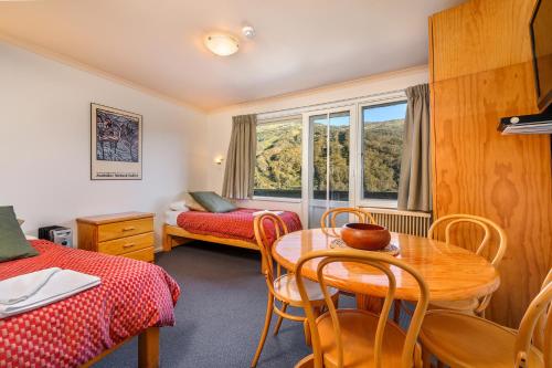 斯瑞德伯卡塞斯公寓山林小屋的客房设有桌椅、床和窗户。