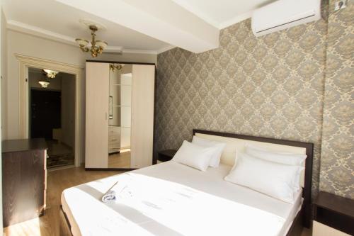 阿拉木图Residential Complex Central 261的卧室配有白色的床和墙壁