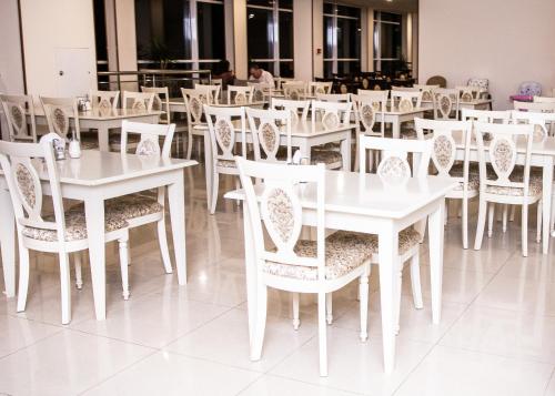 阿德勒自由飞翔酒店的白色的用餐室配有白色的桌椅