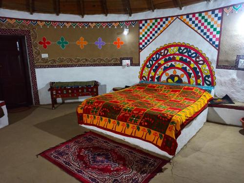 BherandiālaBanni Village Stay的一间卧室配有一张带彩色床罩的床