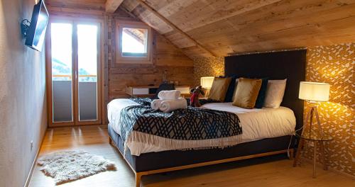 CrésuzLe Vieux Chalet的木制客房内的一间卧室配有一张大床