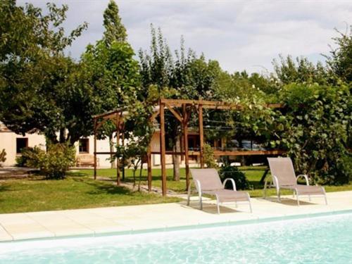 Saint-Jean-de-Thurigneux莱斯巴利里斯酒店的游泳池畔的两把椅子和一个凉亭