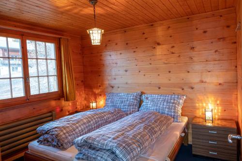 RosswaldChalet Elisabeth的卧室配有木墙内的两张床