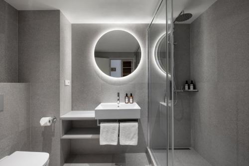 布拉格Botanique Hotel Prague的浴室配有盥洗盆和带镜子的淋浴