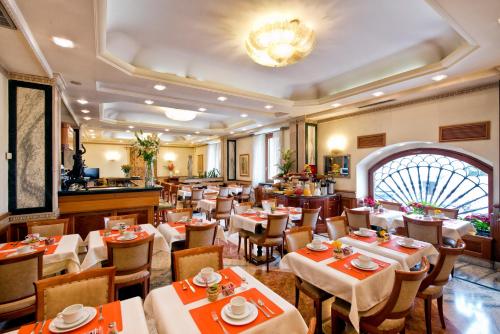 罗马吉奥里纳森纳勒酒店的一间带桌椅和吊灯的餐厅