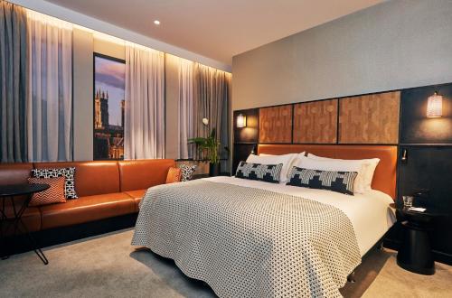 约克Malmaison York的一间卧室配有一张大床和一张沙发