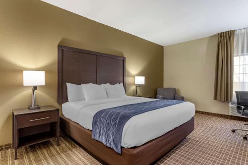 圣罗伯Comfort Inn St Robert-Fort Leonard Wood的酒店客房带一张大床和一把椅子