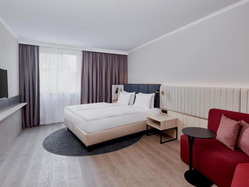 汉堡Crowne Plaza Hamburg-City Alster, an IHG Hotel的卧室配有白色的床和红色沙发