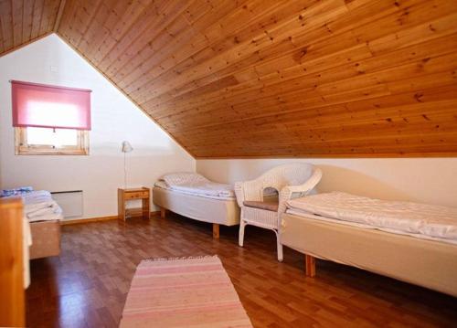 埃克勒Marbyfjärden seaside village Loftet的一间卧室设有两张床和木制天花板