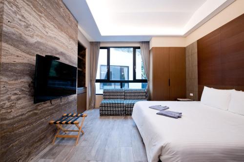 泰安乡苗栗泰安 虎山温泉会馆 的酒店客房设有一张大床和一台电视机。