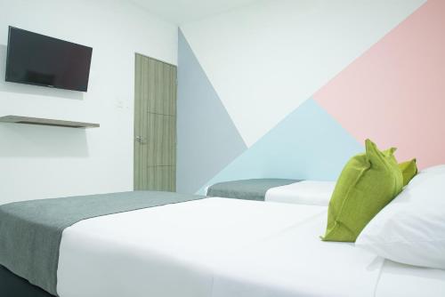 巴兰基亚Hotel Ayenda House Concepción 1317的一间卧室配有两张床和一台平面电视