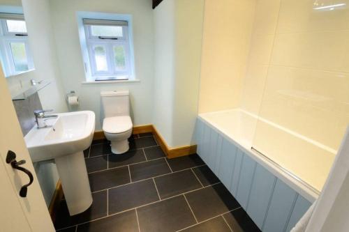 格拉斯米尔Stickle Cottage, Great Langdale的浴室配有盥洗盆、卫生间和浴缸。