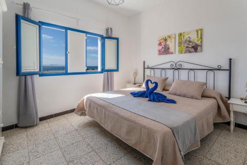 塞博河畔卡莱塔El Graciosero的一间卧室配有一张带蓝色丝带的床