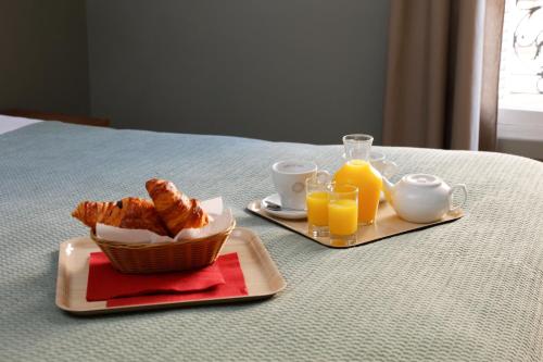 迈松阿尔福格兰德阿尔伯特1尔酒店的桌上的羊角面包和橙汁早餐
