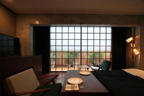 东京D工作室酒店的客房设有床、桌子和大窗户。